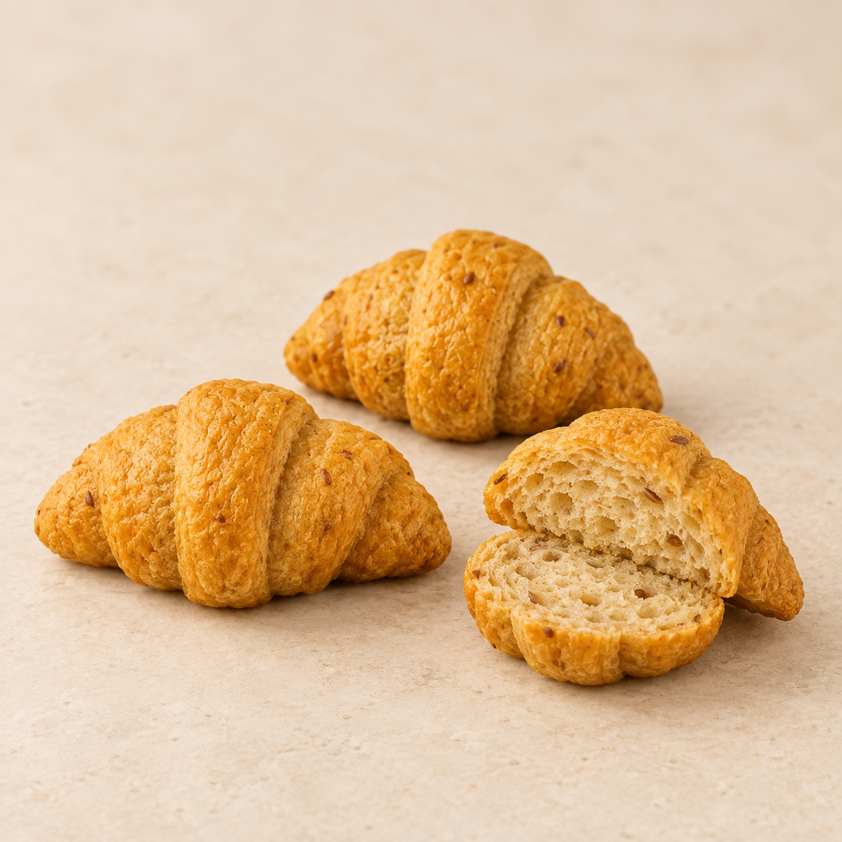 SRSLY mini croissants whole and cut open, showing their golden seeded texture and crumb