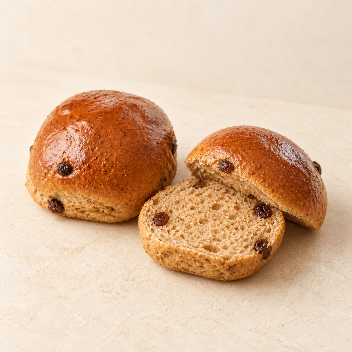 SRSLY Not Cross Buns whole and sliced open, showing their soft spiced crumb and sultanas